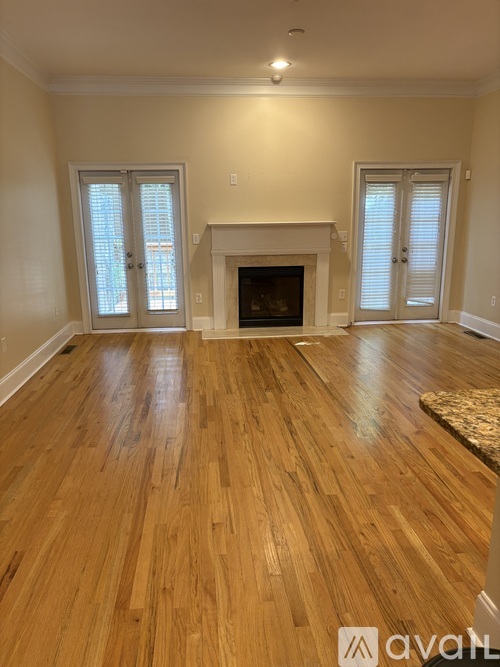 A living room with a fireplace and wood flooring.