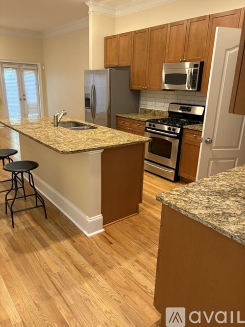 A kitchen with wooden cabinets and granite countertops.