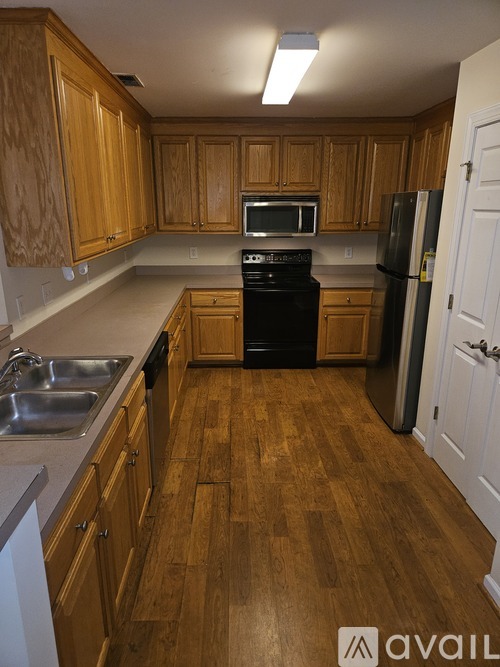 A kitchen with wooden cabinets and a black stove top oven.