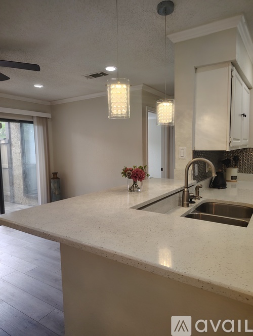 A kitchen with a marble countertop and a sink.