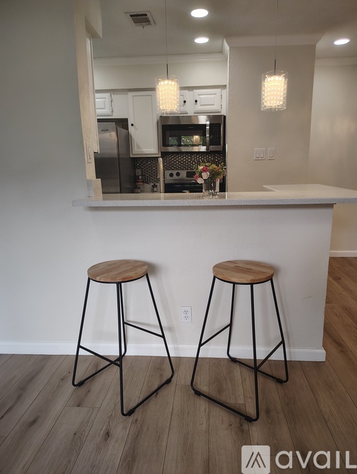 Two bar stools with a white counter in the background.