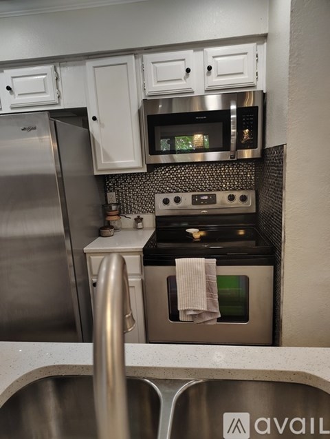 A kitchen with a stainless steel refrigerator and oven.