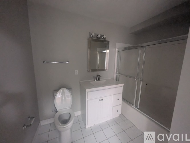 A bathroom with a toilet, sink, and shower.