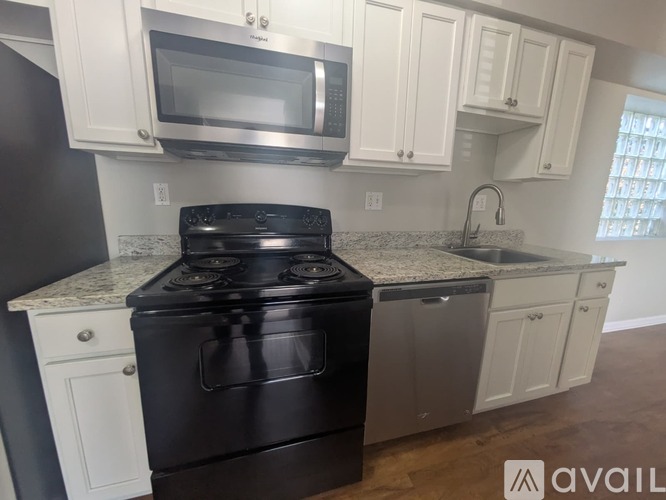 A kitchen with a black stove top oven and white cabinets.