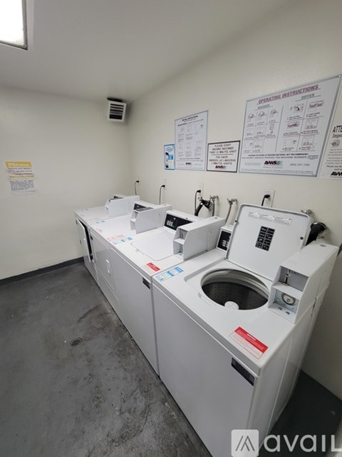 A room with two washing machines and instructions on the wall.