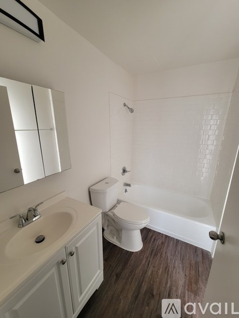 A white bathroom with a toilet, sink, and mirror.