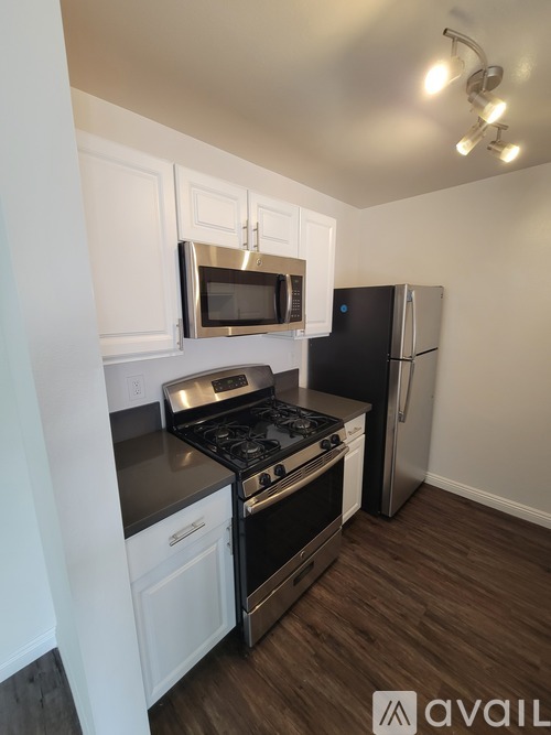 A kitchen with a black stove top oven and a black refrigerator.