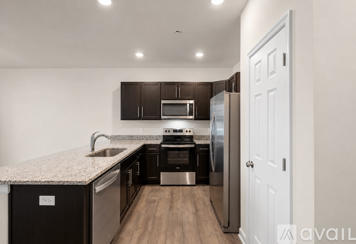 A kitchen with dark brown cabinets and a white door.
