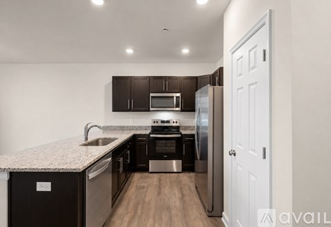 A kitchen with dark brown cabinets and a white door.
