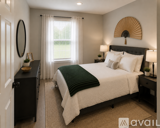 A bedroom with a large bed and a window with curtains.