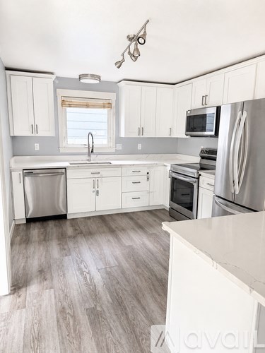 A kitchen with white cabinets and stainless steel appliances.