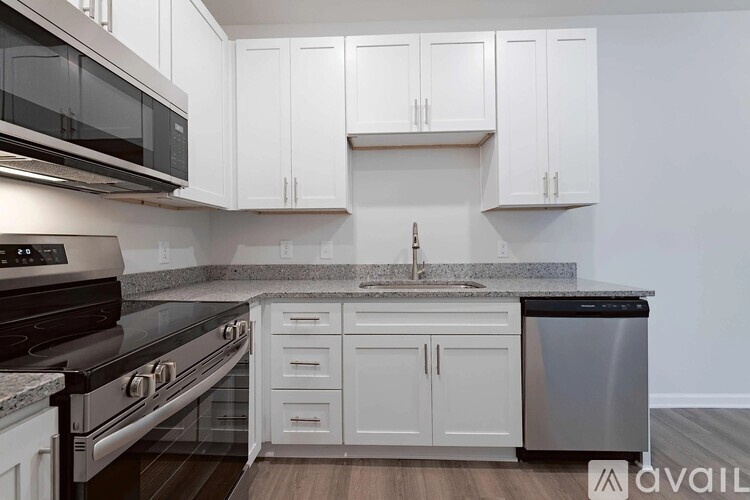 A kitchen with white cabinets and a black stove top oven.