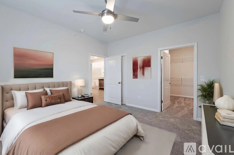 A bedroom with a large bed and a painting on the wall.