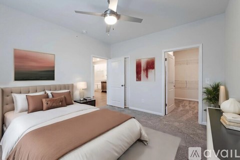 A bedroom with a large bed and a painting on the wall.