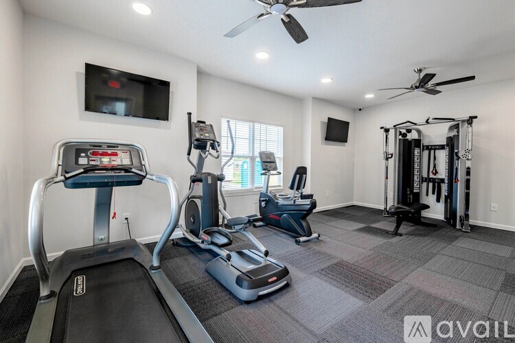 A well-equipped home gym with a treadmill, elliptical trainer, and other exercise machines.