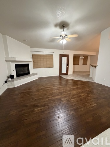 A living room with a fireplace and wooden floors.