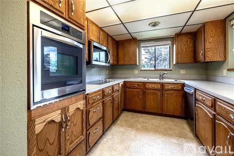 A kitchen with wooden cabinets and a stainless steel oven.