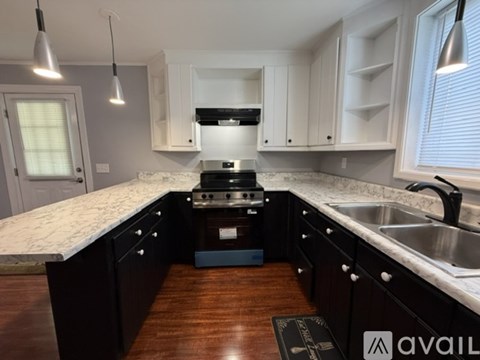 A kitchen with black cabinets and a white countertop.
