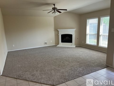 A living room with a fireplace and a rug on the floor.
