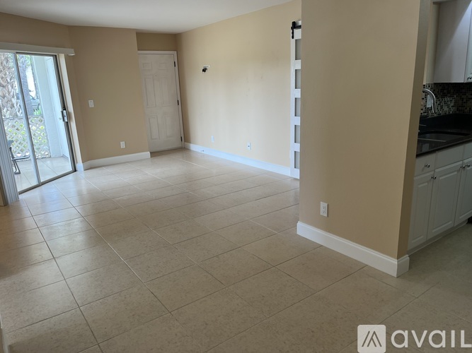 A spacious room with beige walls and tile flooring.