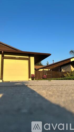 A house with a yellow garage door is for sale.