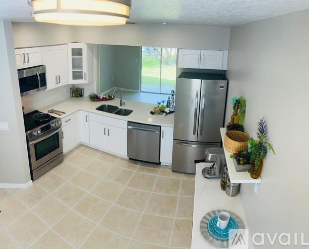 A kitchen with white cabinets and a refrigerator.