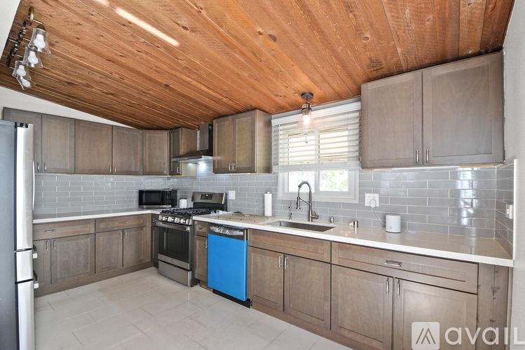 A kitchen with wooden cabinets and a blue dishwasher.