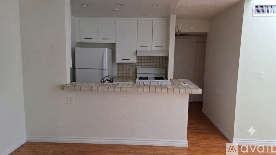 A kitchen with white cabinets and a white fridge.