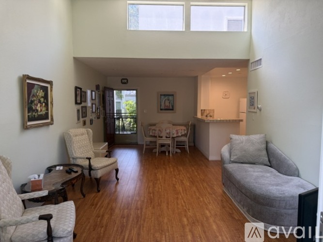 A living room with a grey couch and a table with chairs.
