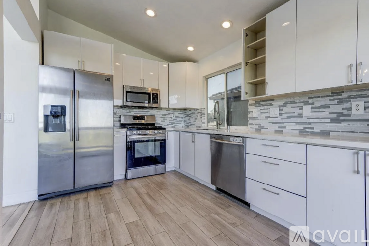 A modern kitchen with stainless steel appliances and white cabinets.