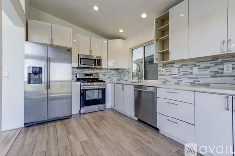 A modern kitchen with stainless steel appliances and white cabinets.