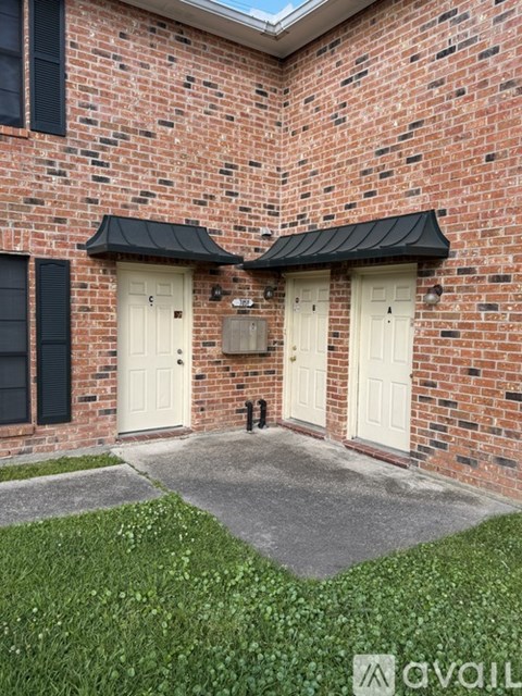 A brick building with two white doors and black awnings.