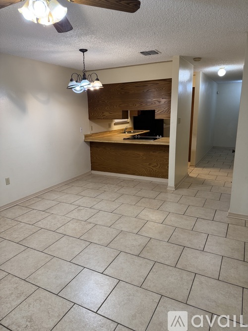 A living room with a tiled floor and a ceiling fan.