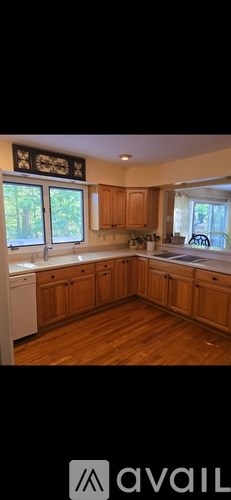 A kitchen with wooden cabinets and a white dishwasher.