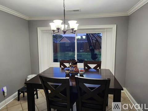 A dining room with a table set for four.