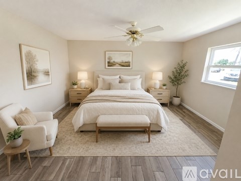 A bedroom with a bed, chair, and a ceiling fan.