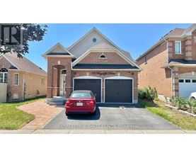 A red car is parked in front of a house with a garage.