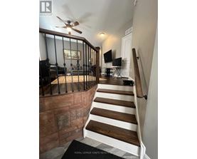 A staircase with a black railing and wooden steps.