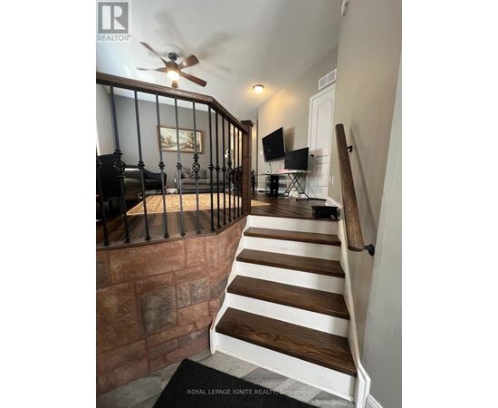 A staircase with a black railing and wooden steps.
