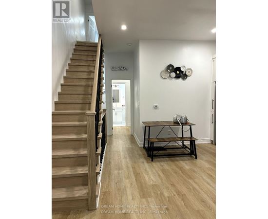 A hallway with a staircase and a table with a phone on it.