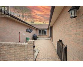 A brick house with a black iron fence and a lamp post.