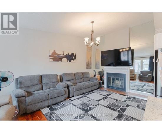 A living room with a grey sofa and a fireplace.