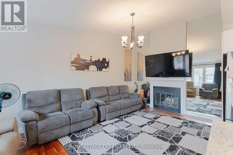 A living room with a grey sofa and a fireplace.