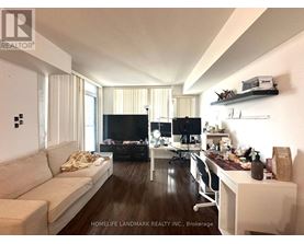 A living room with a couch, a desk, and a television.
