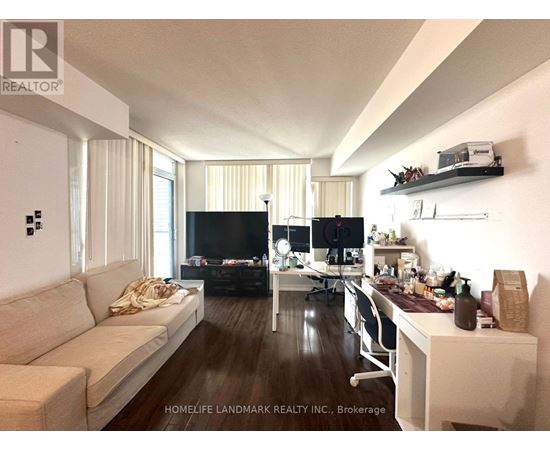 A living room with a couch, a desk, and a television.
