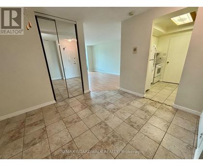 A room with a tiled floor and a glass door leading to another room.