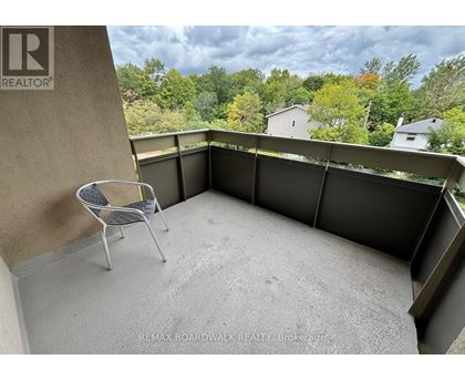 A balcony with a chair and a view of trees.