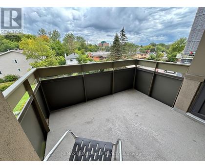 A patio with a table and chairs overlooking a residential area.