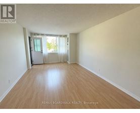 A room with wooden flooring and a sliding glass door.