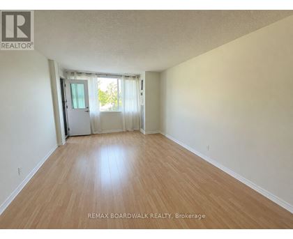 A room with wooden flooring and a sliding glass door.